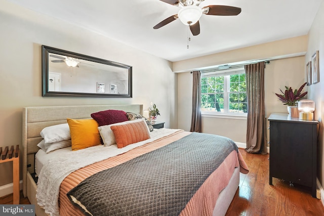 bedroom with a ceiling fan, baseboards, and wood finished floors