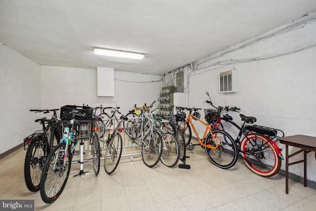 garage with bike storage, concrete block wall, and electric panel