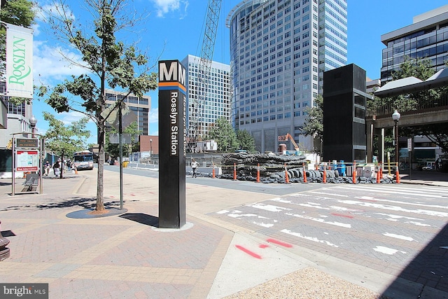 exterior space with sidewalks, curbs, a city view, and street lights