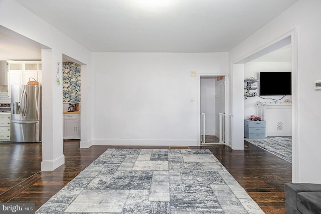 interior space with baseboards and dark wood-style flooring