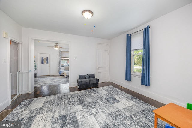 interior space featuring baseboards, wood finished floors, and a healthy amount of sunlight