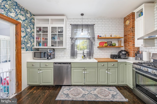 kitchen featuring open shelves, a sink, green cabinetry, and appliances with stainless steel finishes