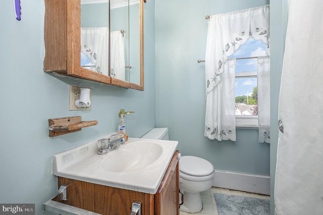bathroom featuring vanity, baseboards, and toilet