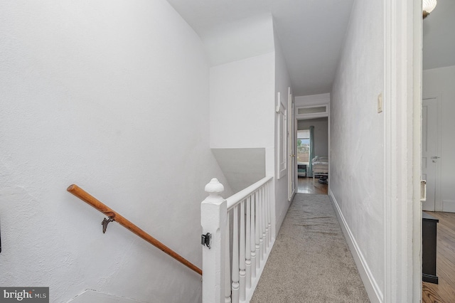 corridor featuring baseboards and an upstairs landing