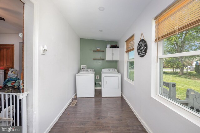 laundry room with cabinet space, independent washer and dryer, baseboards, and dark wood-type flooring