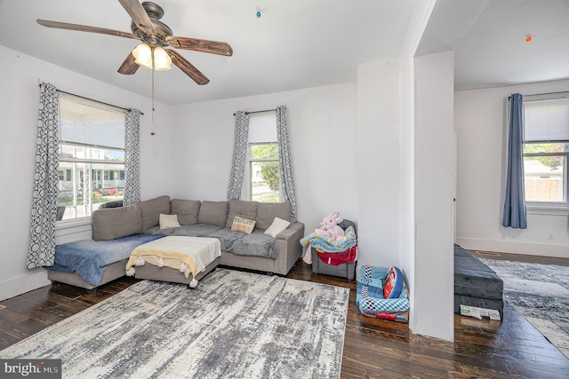 living room featuring ceiling fan, baseboards, plenty of natural light, and wood finished floors