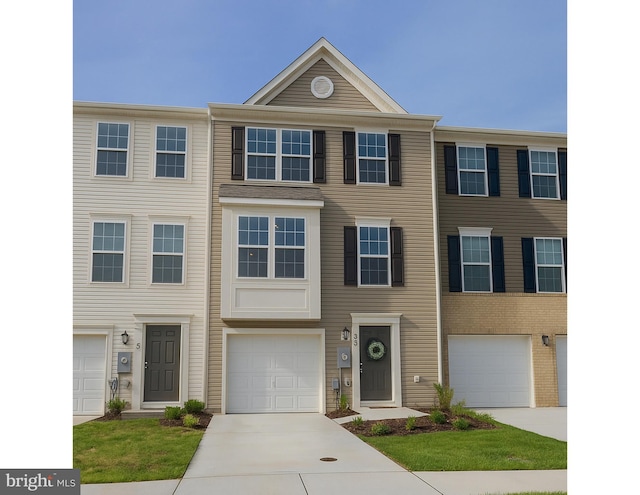 multi unit property featuring an attached garage and driveway