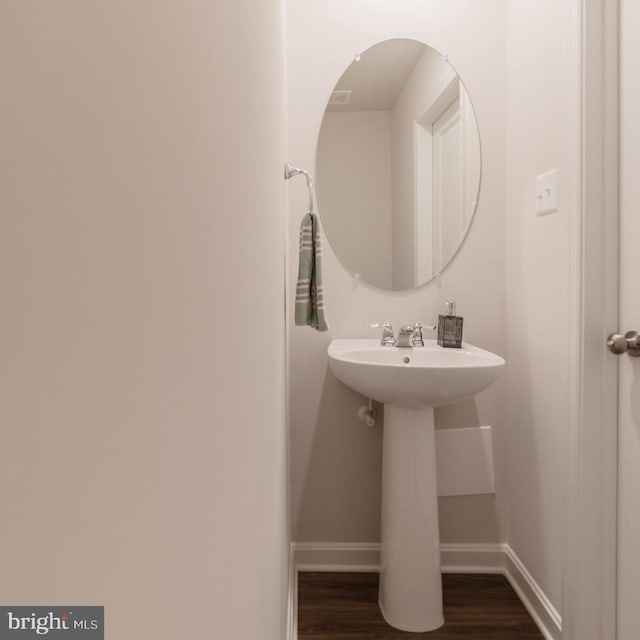 bathroom with baseboards and wood finished floors