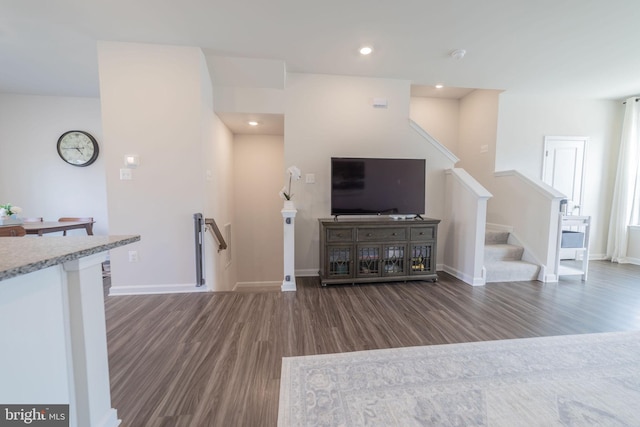 unfurnished living room with recessed lighting, baseboards, and wood finished floors