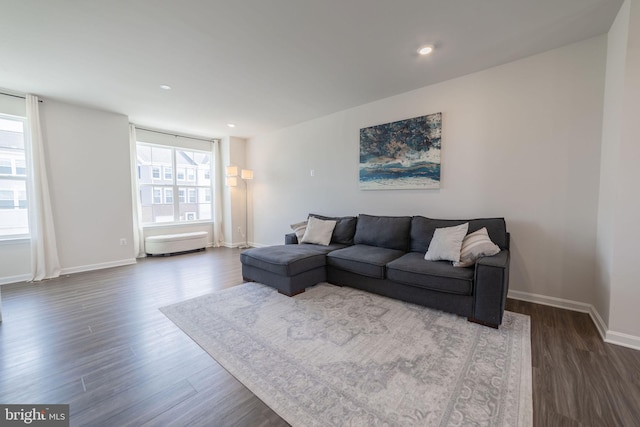 living room featuring dark wood-type flooring, recessed lighting, and baseboards