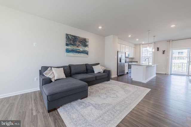 living area with baseboards, recessed lighting, and dark wood-type flooring