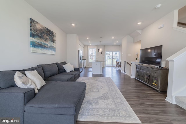 living room featuring dark wood-style flooring, baseboards, and recessed lighting