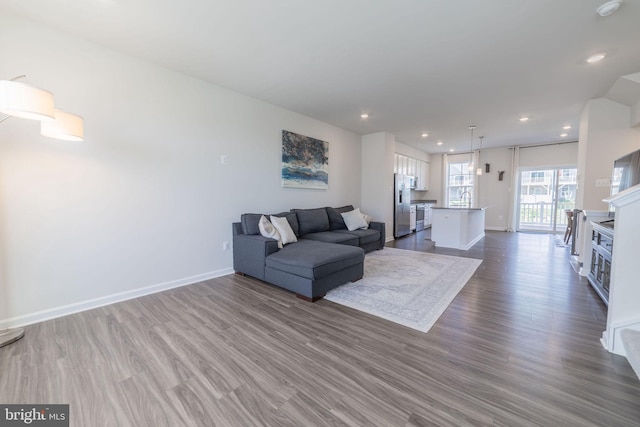living area with recessed lighting, baseboards, and dark wood-style floors