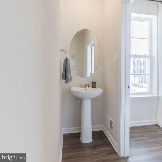 bathroom with baseboards, wood finished floors, and visible vents
