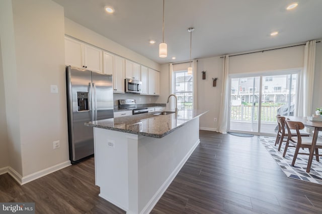 kitchen featuring baseboards, dark wood-type flooring, white cabinets, a sink, and appliances with stainless steel finishes