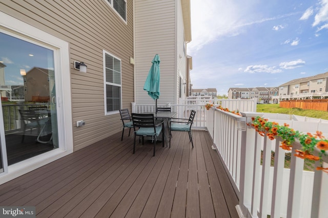 deck with a residential view and outdoor dining area