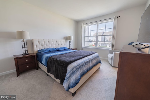 bedroom featuring baseboards and light carpet