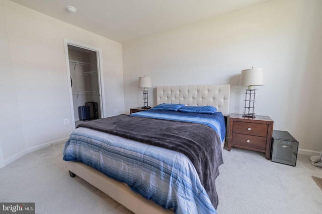 carpeted bedroom featuring baseboards, a closet, and a walk in closet