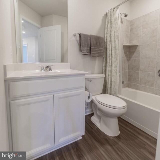 full bath with toilet, shower / bath combination with curtain, wood finished floors, and vanity