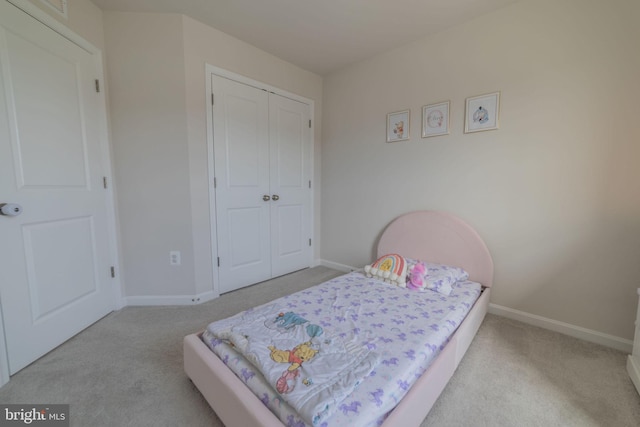 carpeted bedroom with baseboards and a closet