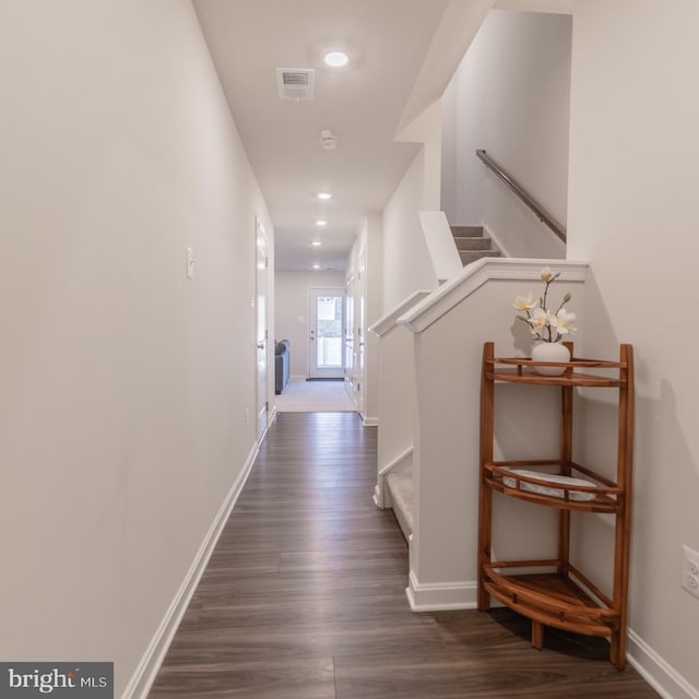 hallway with visible vents, baseboards, dark wood-style floors, and stairway