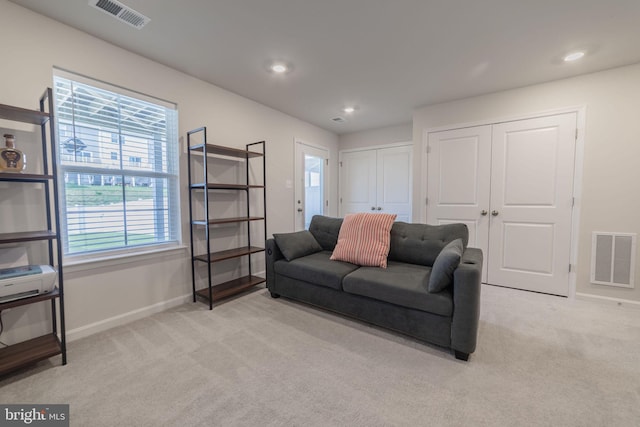 living area with baseboards, light colored carpet, recessed lighting, and visible vents