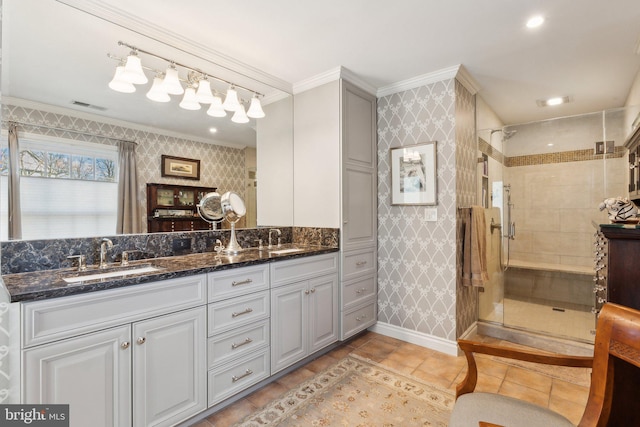 full bathroom with visible vents, ornamental molding, wallpapered walls, a shower stall, and a sink