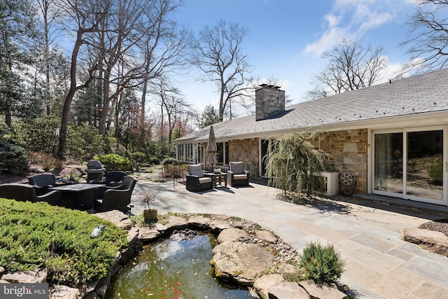view of patio / terrace featuring an outdoor living space and a small pond