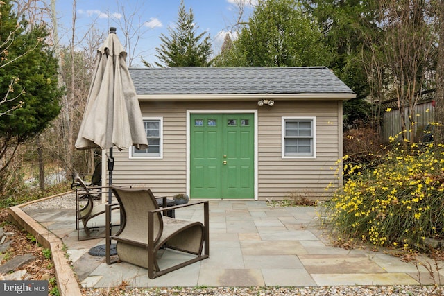 view of outdoor structure featuring fence and an outbuilding