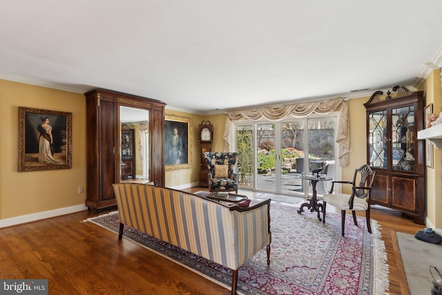 living room with baseboards, ornamental molding, and wood finished floors
