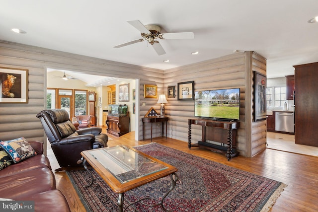 living room with a ceiling fan, wood finished floors, and a healthy amount of sunlight