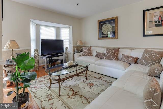living area with wainscoting and wood finished floors