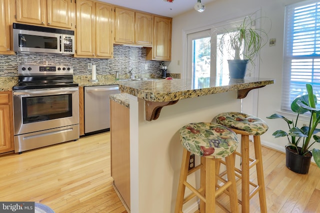 kitchen featuring a breakfast bar, stainless steel appliances, and backsplash