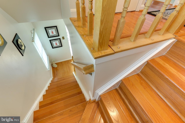 stairway with baseboards and wood finished floors