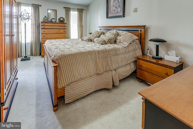 bedroom featuring light colored carpet and multiple windows