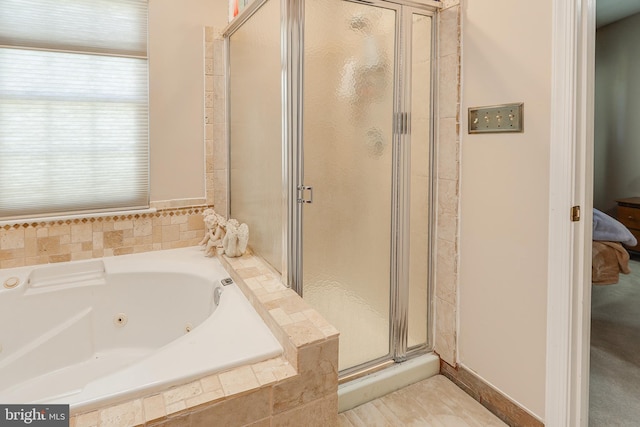 bathroom with a shower stall and a tub with jets