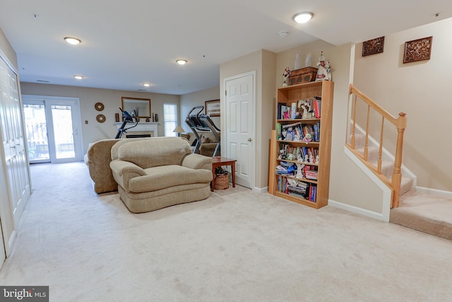living room with carpet floors, stairs, plenty of natural light, and a fireplace