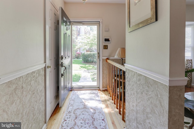 entrance foyer with light wood finished floors and wainscoting