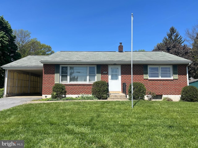 ranch-style home with a front lawn, aphalt driveway, a chimney, brick siding, and a carport