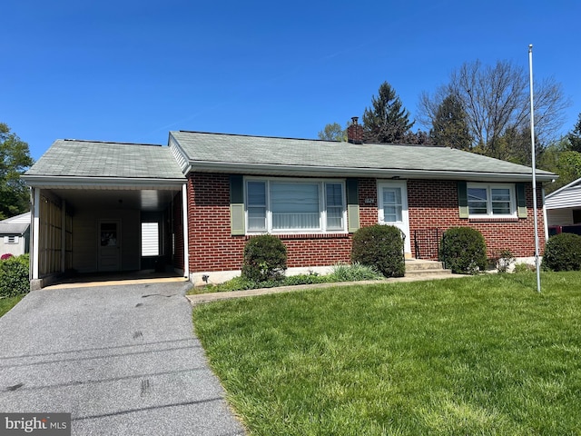 ranch-style home featuring aphalt driveway, brick siding, a front lawn, a shingled roof, and an attached carport