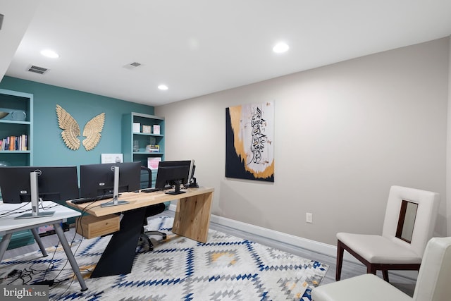 office space with recessed lighting, visible vents, and wood finished floors