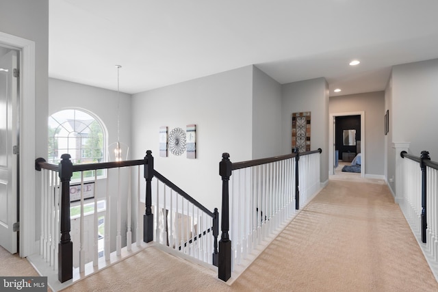 corridor with a chandelier, carpet, recessed lighting, baseboards, and an upstairs landing