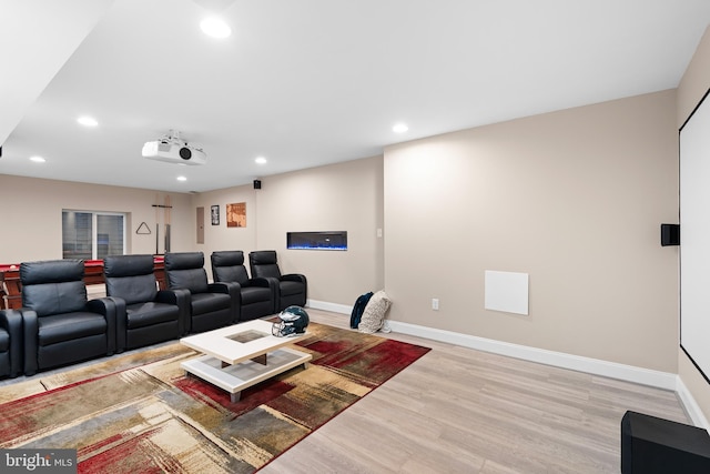 cinema room featuring recessed lighting, light wood-style floors, and baseboards