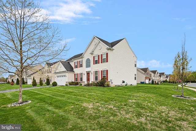 traditional-style home featuring a residential view, an attached garage, and a front lawn