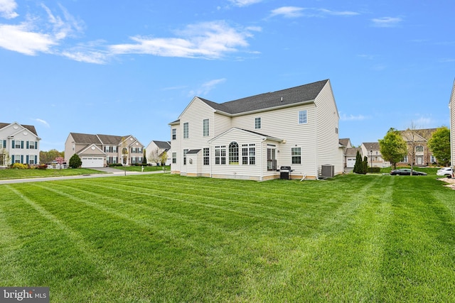 back of property featuring a yard, a residential view, and cooling unit