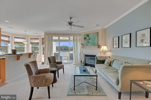 living room featuring a ceiling fan, visible vents, crown molding, light colored carpet, and a glass covered fireplace