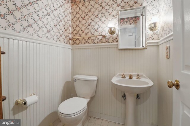9116 John Way, Fairfax Station, VA 22039 - half bathroom featuring wallpapered walls, toilet, tile patterned flooring, and a sink