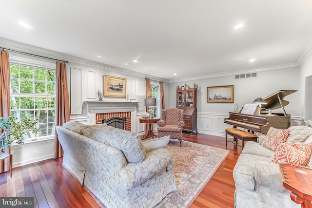 318 Longwood Rd, Kennett Square, PA 19348 - living area featuring crown molding, a brick fireplace, wood finished floors, a decorative wall, and recessed lighting