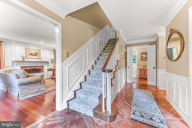 318 Longwood Rd, Kennett Square, PA 19348 - stairway featuring ornamental molding, a decorative wall, wainscoting, a brick fireplace, and recessed lighting