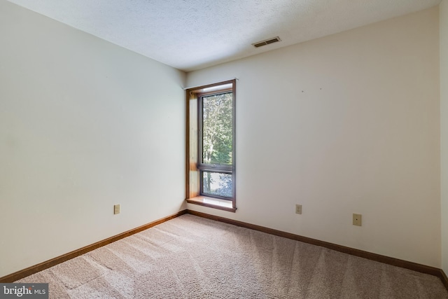 spare room featuring baseboards, carpet flooring, and visible vents